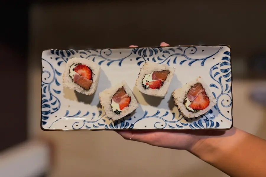 Roll Sakura de Nami en plato japonés azul: salmón, frutilla y queso.
